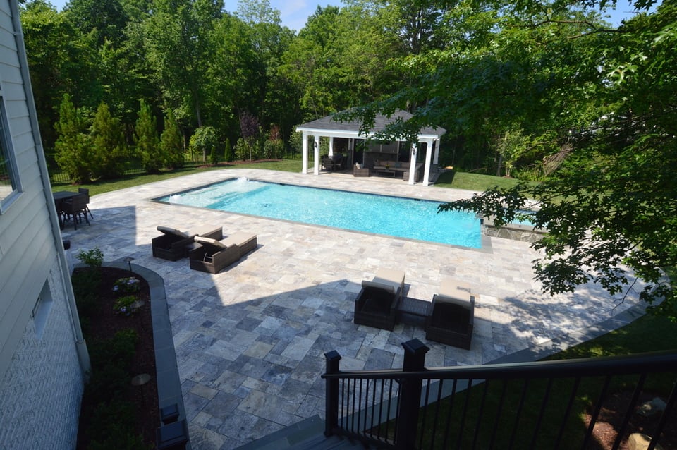 View from second-level deck over pool, patio, covered area, and pool house by Deckscapes of Virginia