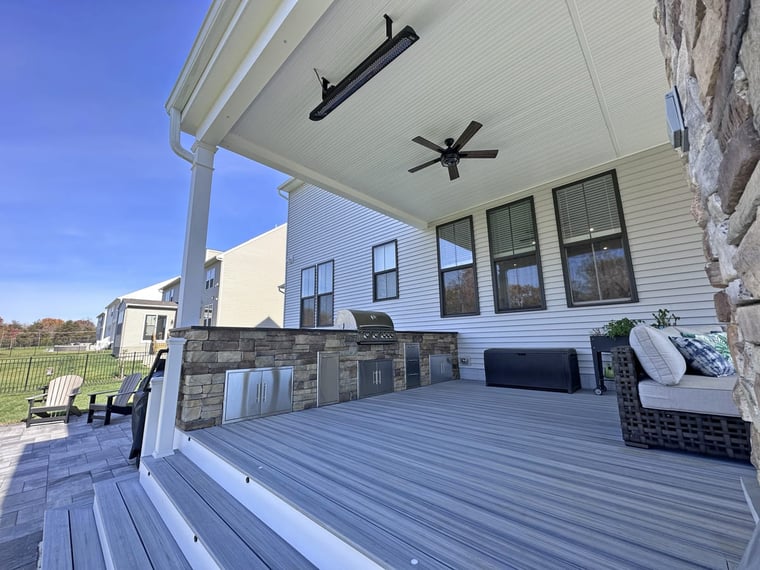 Steps leading up to backyard deck with Bromic heater and custom stone outdoor kitchen in Northern Virginia