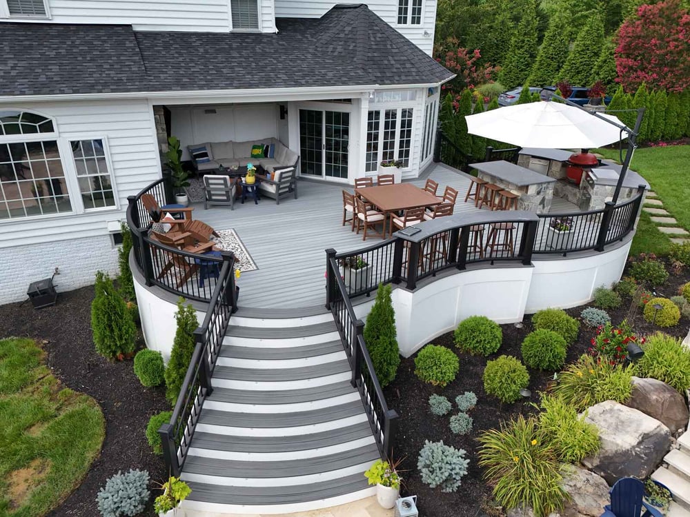 Beautiful round deck with dining, lounging, and barbecue area, designed by Deckscapes of Virginia