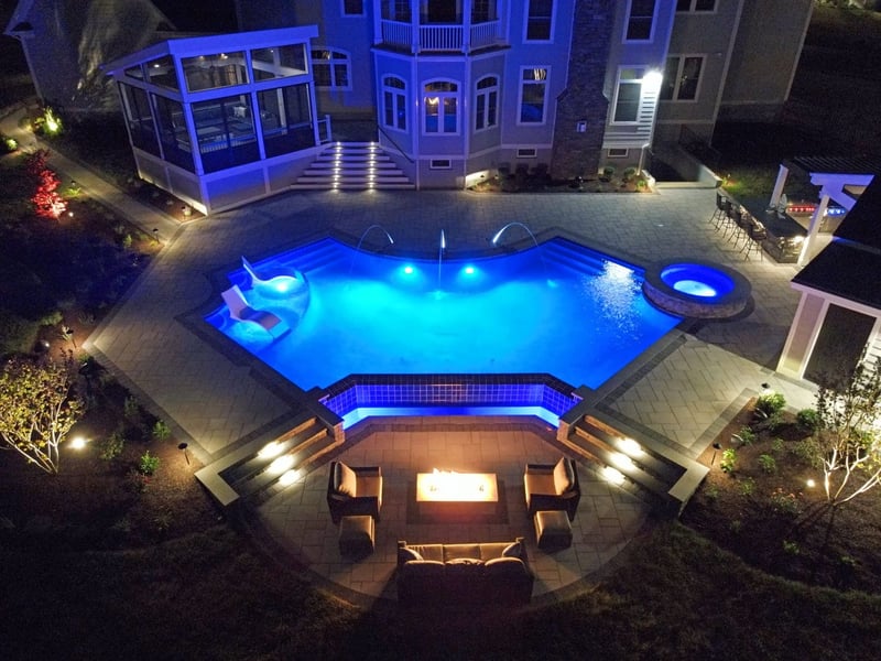 Aerial view of pool, patio, porch, and deck at night