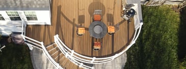 Aerial view of raised deck with curved railing and staircase