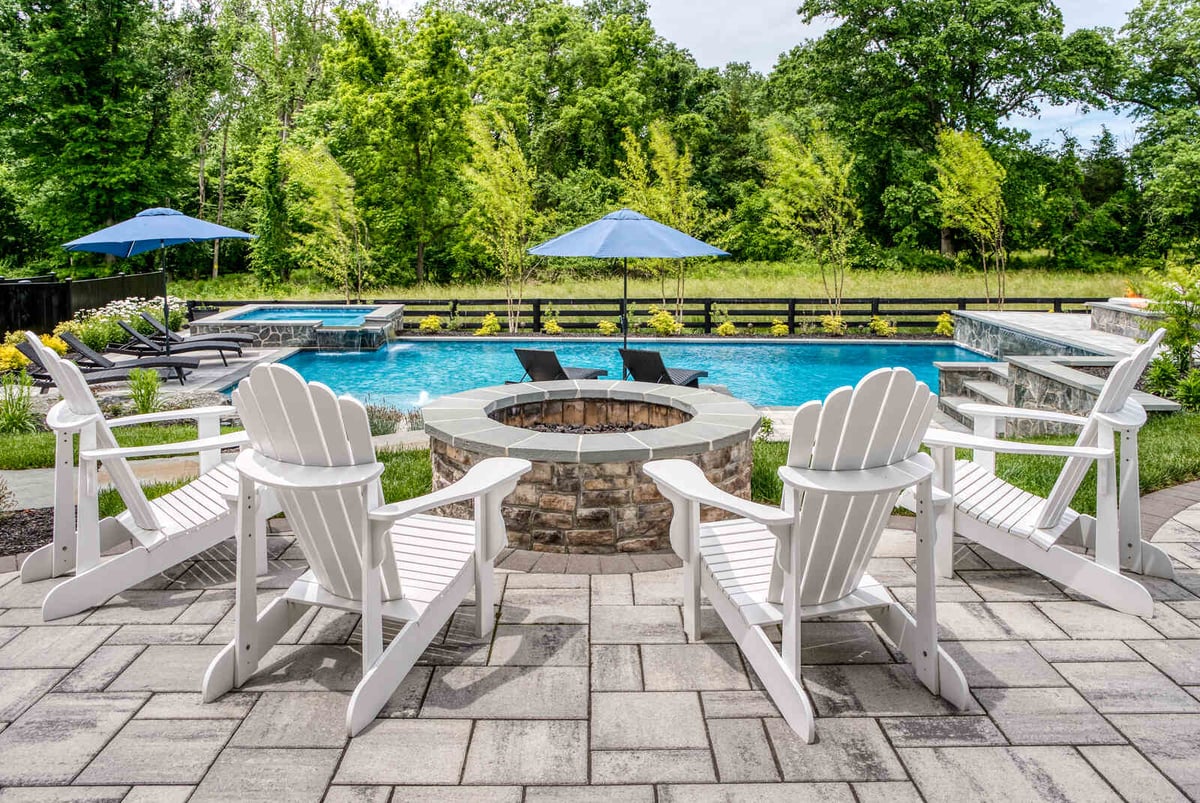 chair around firepit on stone patio looking at in ground pool in Northern Virginia