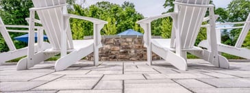 Concrete patio detailing with two white Adirondack chairs