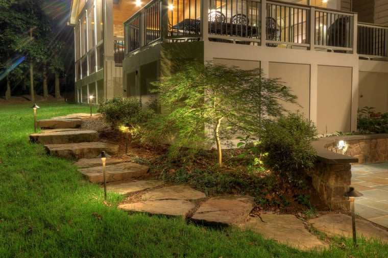 custom lighting alongside stone stairs next to deck