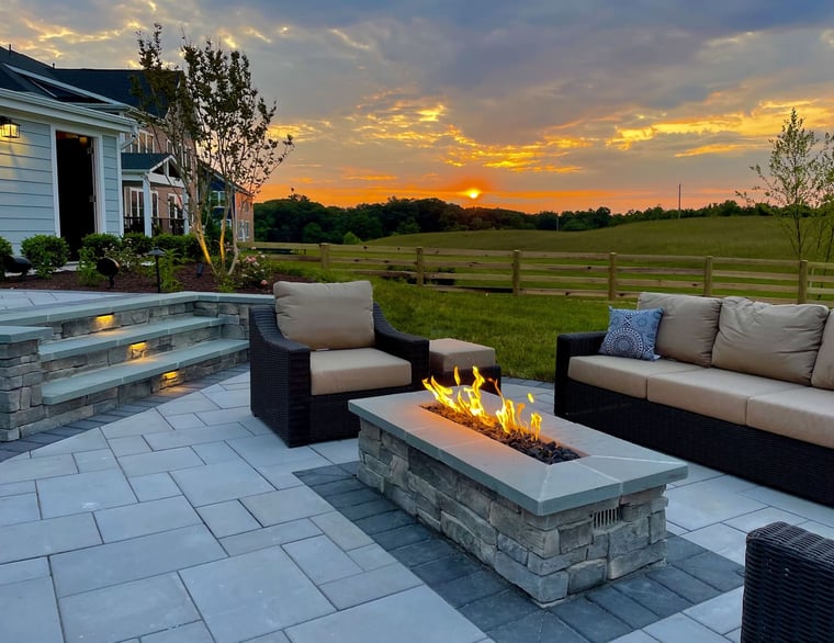 Custom patio area with stone fireplace and built-in lighting under steps