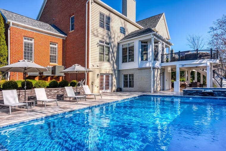 Custom swimming pool with retaining wall behind pool chairs