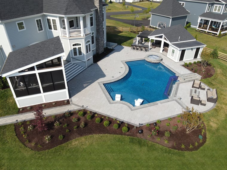 Drone view of screened-in patio and pool area with patio