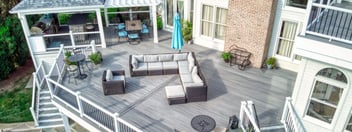 Expansive second story deck with white posts and attached pergola