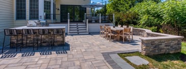 Flagstone patio with custom stacked stone outdoor kitchen and stairs to deck