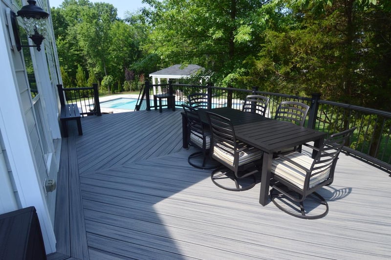 Gray composite decking material with outdoor dining table