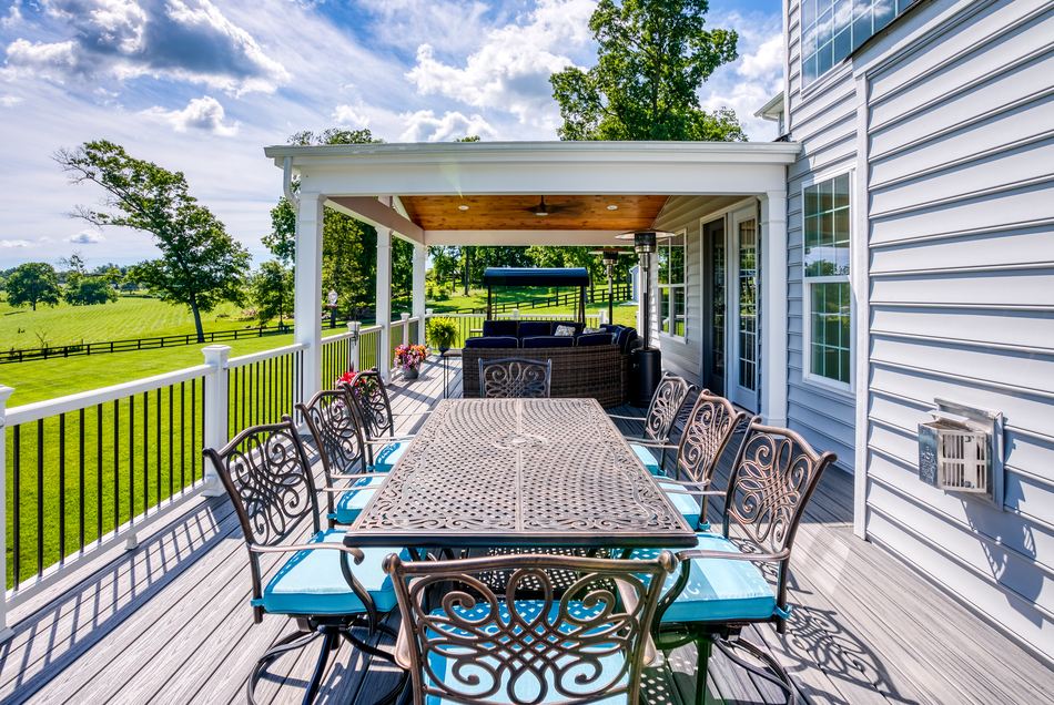 Half covered backyard deck area with dining area