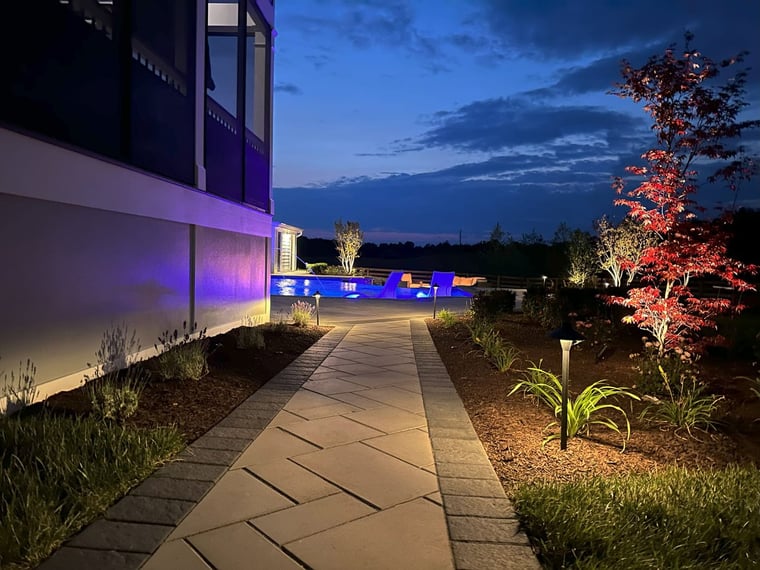 Lighting and landscaping features on stone pathway at dusk