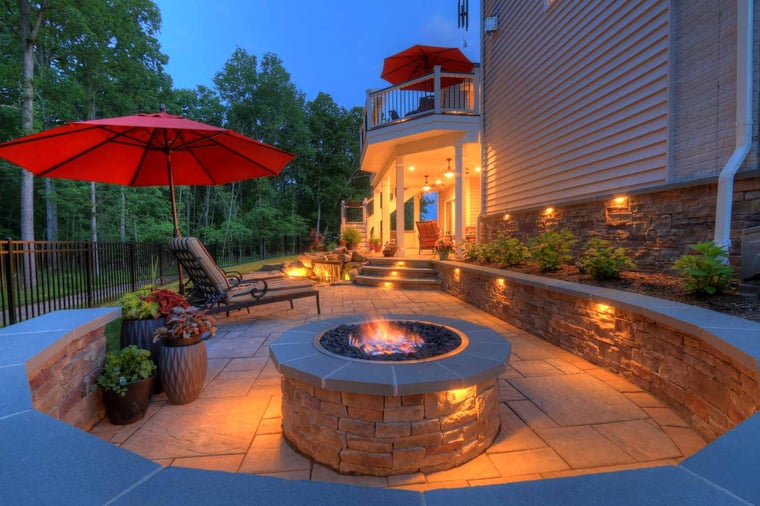 Luxury patio at dusk with built-in lighting and fireplace