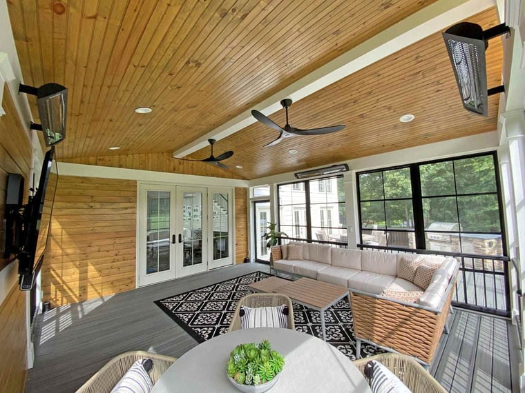 Porch interior with black trim on windows and two ceiling fans