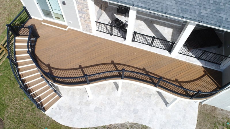 Raised composite deck build with curved staircase and railing