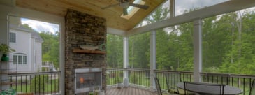 Screened-in porch with white posts and vaulted ceiling