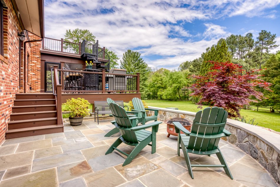 Stone patio with built-in seating wall and fireplace
