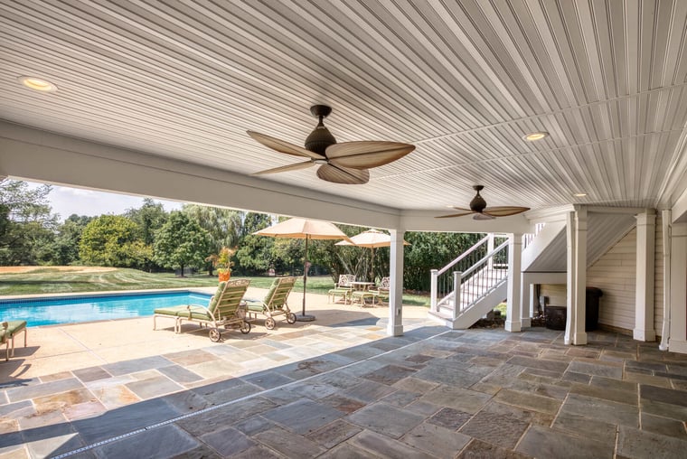 Under deck system with ceiling fans by in-ground pool 