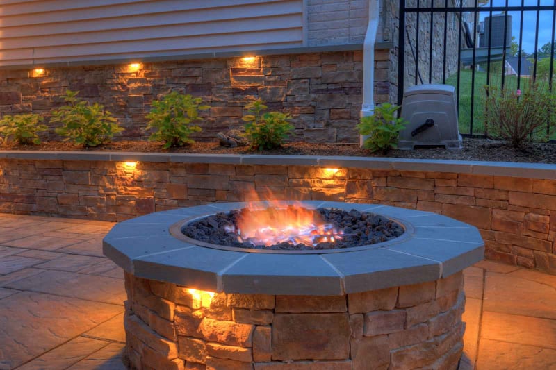 Up close view of custom firepit with built-in lighting on patio