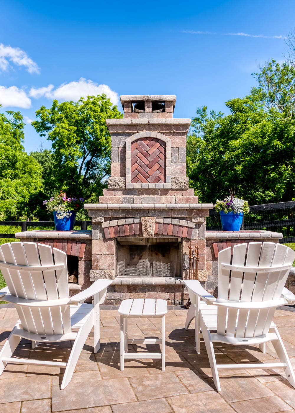 Fireplace on patio with log storage and herringbone pattern by Deckscapes of Virginia