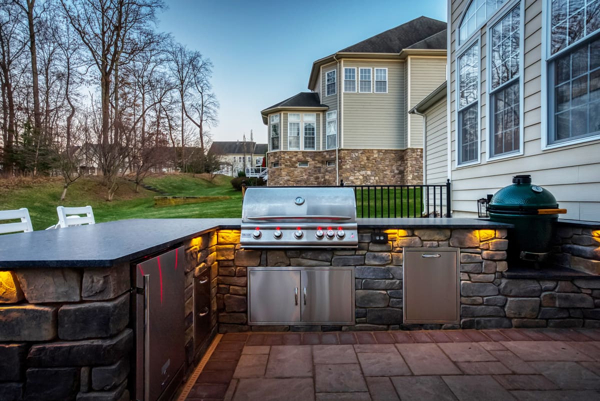 L-shaped outdoor kitchen with smoker by Deckscapes of VA