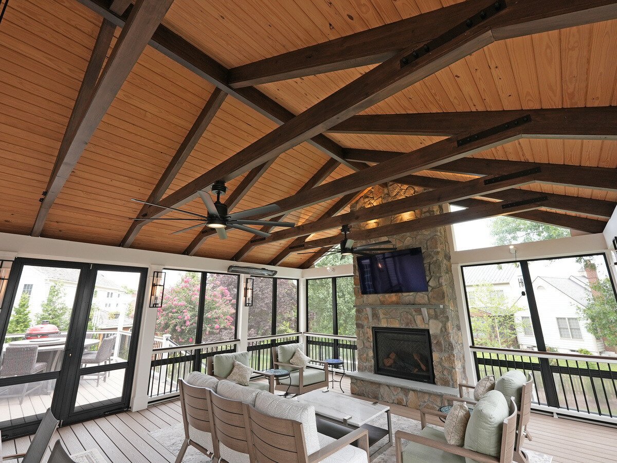 Large screened-in porch interior with fireplace and a-frame roof by Deckscapes of VA