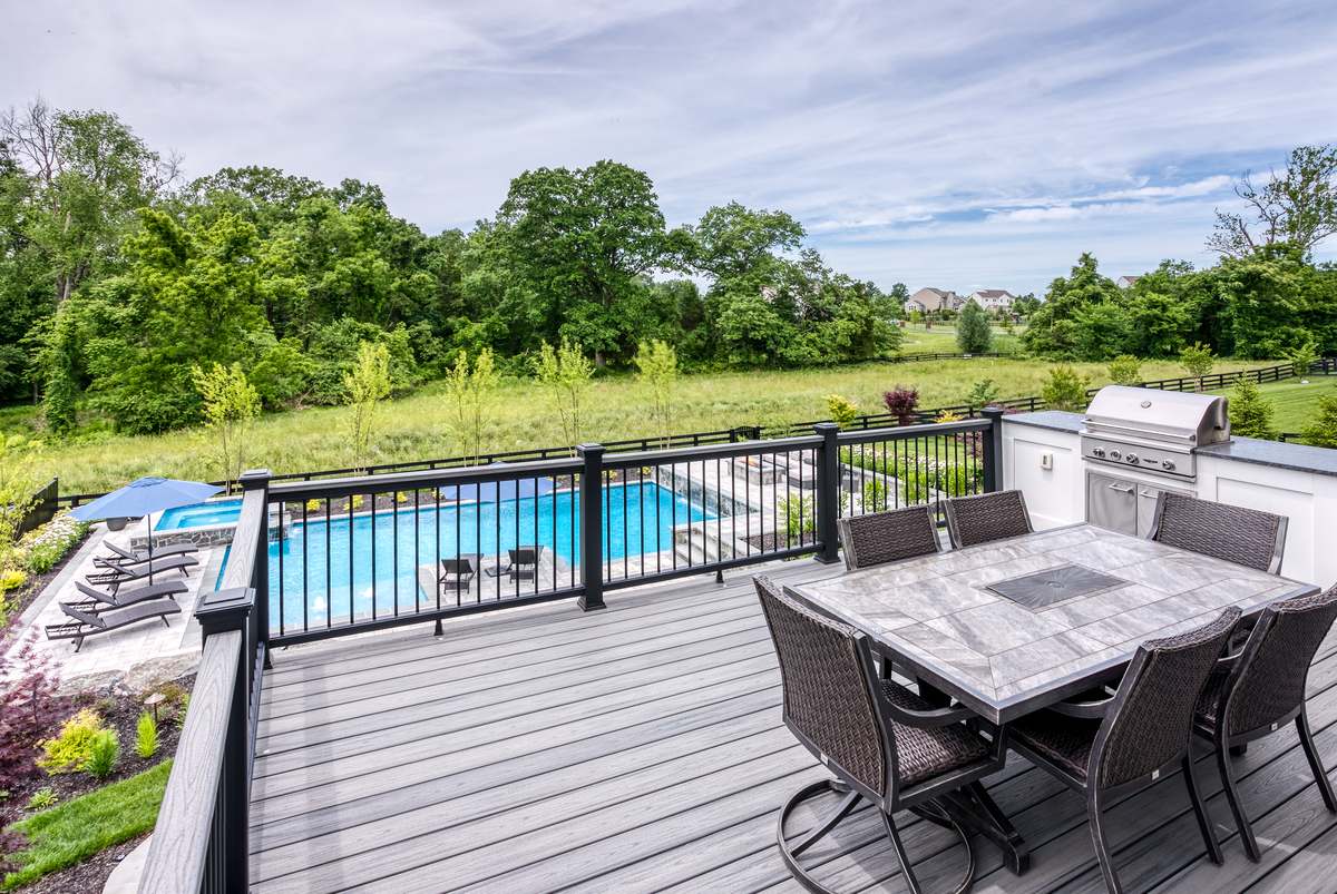 Deck view of pool area with outdoor kitchen